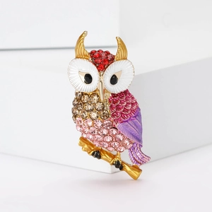 Elegant owl brooch with sparkling rhinestones and colorful enamel on a golden branch