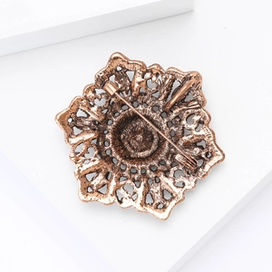 Detailed back view of vintage bronze flower brooch showing secure rotating safety clasp