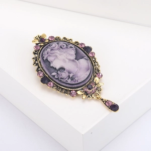 Vintage royal cameo brooch with purple female relief and sparkling rhinestones on gold base