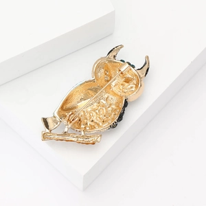 Macro view of the golden owl brooch back with a secure horizontal pin mechanism