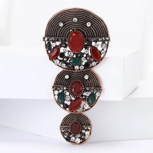 Baroque vintage alloy brooch with red green gemstones and rhinestones on white platform
