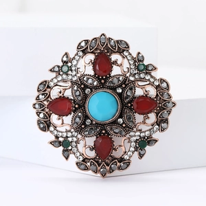 Broche bohème vintage avec turquoise et strass rouges sur cadre en bronze de style rétro