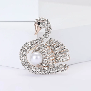 Élégante broche cygne avec strass blancs et grande perle sur une base en métal doré