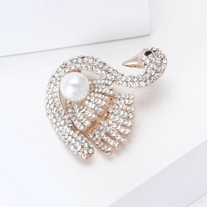 Broche cygne élégante en finition dorée avec strass scintillants et une grande perle blanche
