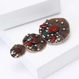 Vintage Baroque alloy brooch with red stones and multicolored rhinestones on white base
