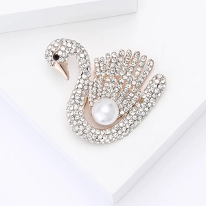 Vue détaillée d'une broche cygne en or rose avec des strass blancs et une grande perle