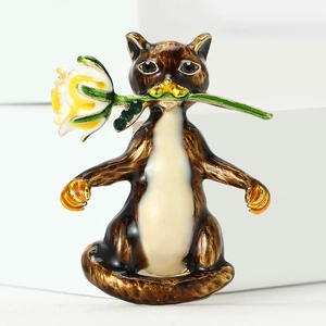 Détail d'une broche chat en émail marron tenant une rose avec cristaux verts