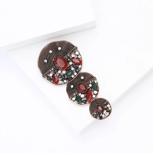 Vintage Baroque alloy brooch with colorful rhinestones on a minimalist white platform