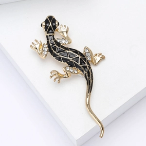 Détail de la broche gecko avec émail noir et strass blancs brillants sur métal doré