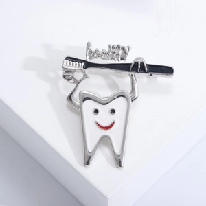 Detail showing creative tooth enamel brooch with healthy toothbrush and smiling face design