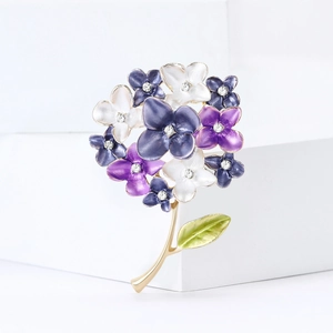 Close-up of purple enamel hydrangea flower brooch with crystal centers on gold base