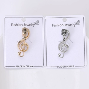 Detail of gold and silver music note pins with G-clef and microphone on display cards