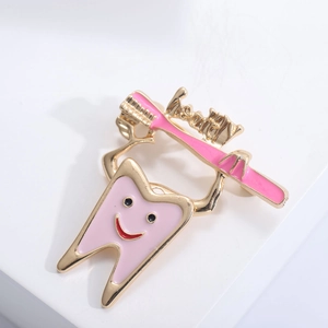 Detailed view of pink enamel tooth brooch with healthy dental care design and toothbrush
