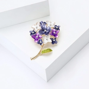 Macro detail of enamel hydrangea brooch with purple petals and crystal stamen accents