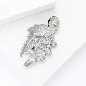 Detailed back view of the parrot brooch showing the secure pin clasp and textured silver metal