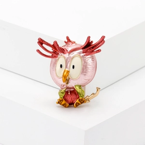Pink alloy owl brooch with colorful enamel finish and green leaf detail on white display