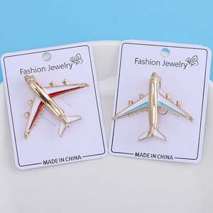Detailed macro view of plane-shaped alloy brooches with colorful drip oil finish on card