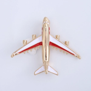 Macro detail of airplane brooch with white and red enamel on golden metal base