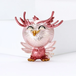 Creative pink pearl owl brooch with deer antlers on a minimalist white platform