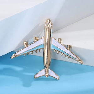 Detail of creative airplane brooch badge featuring gold metal outline and blue enamel finish