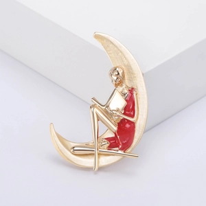 Broche créative en forme de croissant de lune avec une fille lisant en robe rouge