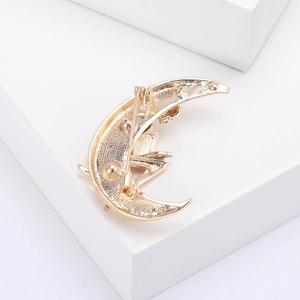 Détail du dos d'une broche lune dorée avec finition texturée et fermoir de sécurité fiable