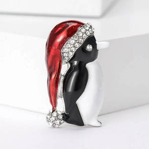 Detail of penguin brooch with red Santa hat featuring sparkling rhinestones and enamel