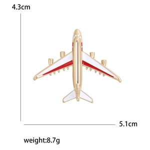 Minimalist airplane brooch in gold alloy with red and white enamel detailing