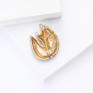 Macro shot of the textured gold metal back and secure pin clasp on the pangolin brooch
