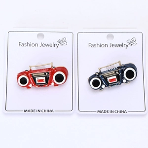 Detail of vintage radio enamel brooches in red and navy blue with fashion display cards