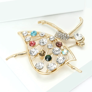 Macro di un'elegante spilla da ballerina in metallo dorato con strass multicolori