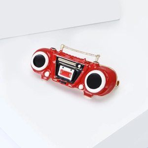Macro shot of vintage red radio brooch with alloy enamel finish on a white display