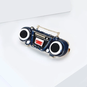 Detail of retro radio brooch with dark blue enamel finish and golden metal handle