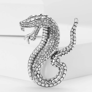 Macro detail of cobra brooch with sparkling rhinestones and silver-plated scale texture