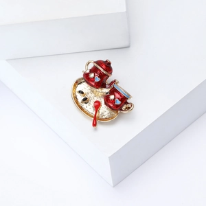 Detail of red enamel teapot and teacup brooch on golden tray with heart accents