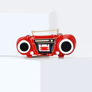 Retro radio brooch with red enamel and gold accents on a clean product display