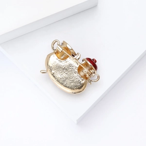 Close-up of alloy tea pot brooch back view with gold plating and secure safety pin fastener