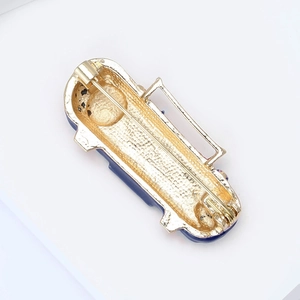 Detail of vintage radio brooch back with golden alloy finish and safety pin closure
