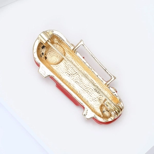 Detail view of the vintage bus brooch back showing the gold alloy finish and metal pin clasp