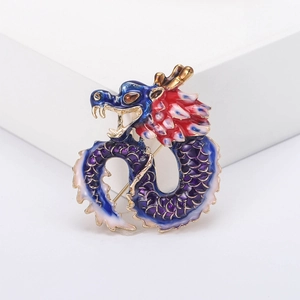 Detail of dragon brooch with blue and purple enamel coating on a white display pedestal