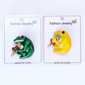 Detailed macro view of creative frog brooches with colorful enamel and heart motifs