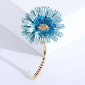 Macro detail of blue gradient enamel daisy brooch with shiny gold metallic finish