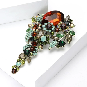 Makroaufnahme der Vintage Kristall-Blumenbrosche mit bernsteinfarbenem Stein und Strass