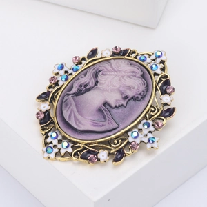 Dettaglio della spilla cammeo vintage con profilo femminile viola e strass colorati