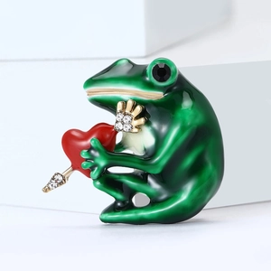 Green enamel frog brooch with red heart and sparkling rhinestones on white geometric base