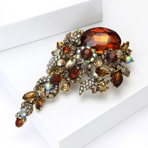 Makro-Detail einer Vintage-Brosche mit großem bernsteinfarbenem Kristall und Strass