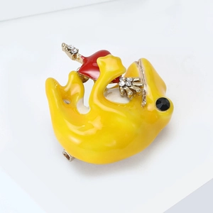 Detail of yellow enamel frog brooch with black rhinestone eye and red heart accessory