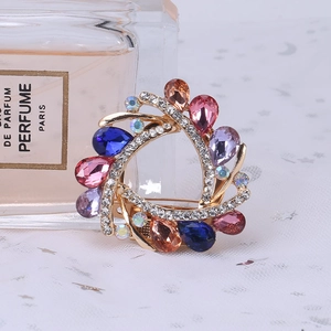 Macro shot of vintage round floral wreath brooch with multicolor pear-cut crystals