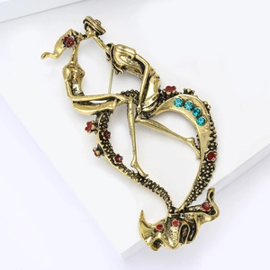 Detail of vintage heart brooch featuring kissing lovers with red and blue rhinestones