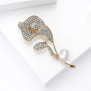 Detailansicht der luxuriösen Orchideenbrosche mit Strass und Perle auf weißem Sockel